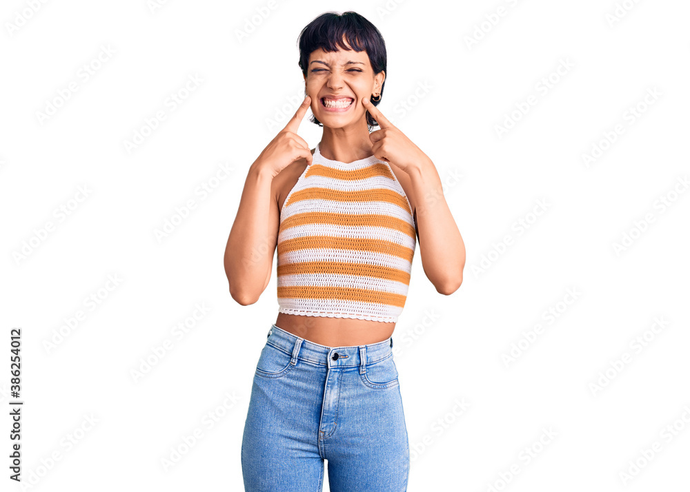 Fototapeta premium Young brunette woman with short hair wearing casual clothes smiling with open mouth, fingers pointing and forcing cheerful smile