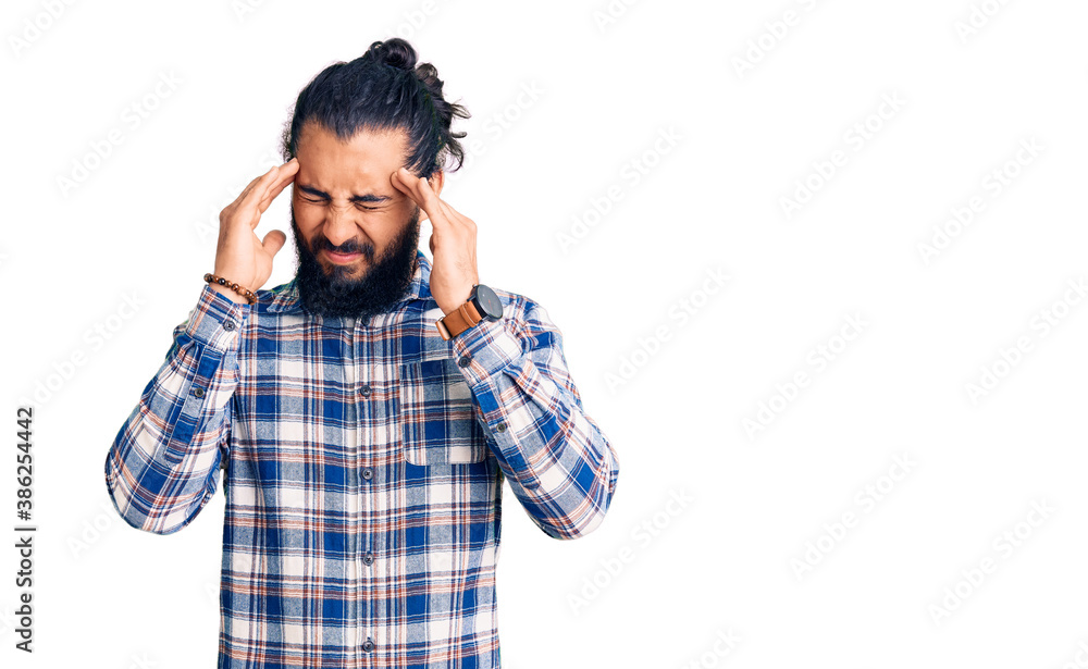 Young arab man wearing casual clothes with hand on head for pain in head because stress. suffering migraine. Young arab man wearing casual clothes with hand on head for pain in head because stress. suffering migraine.