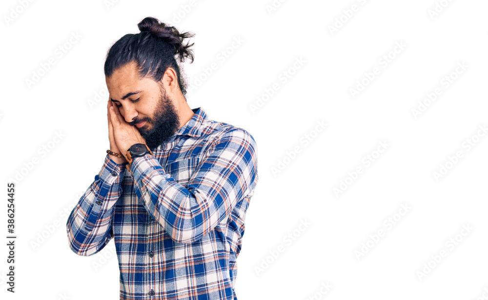 Young arab man wearing casual clothes sleeping tired dreaming and posing with hands together while smiling with closed eyes. Young arab man wearing casual clothes sleeping tired dreaming and posing with hands together while smiling with closed eyes.