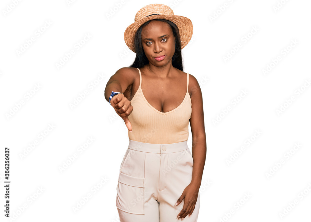 Young black woman wearing summer hat looking unhappy and angry showing rejection and negative with thumbs down gesture. bad expression. Young black woman wearing summer hat looking unhappy and angry showing rejection and negative with thumbs down gesture. bad expression.
