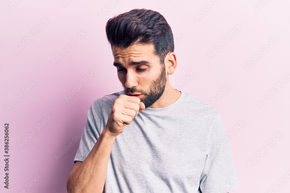 Young handsome man with beard wearing casual t-shirt feeling unwell and coughing as symptom for cold or bronchitis. health care concept. Young handsome man with beard wearing casual t-shirt feeling unwell and coughing as symptom for cold or bronchitis. health care concept.