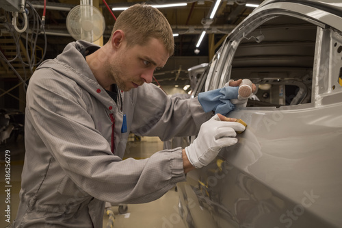 Employee car body painting shop eliminates a small metal defect