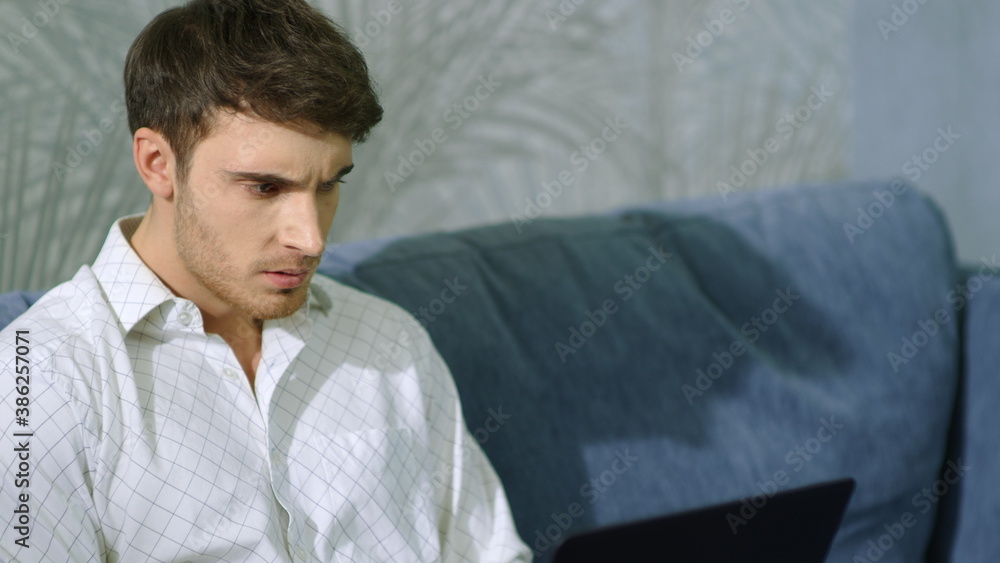 Wicked man hitting laptop indoors. Angry guy using computer inside. Wicked man hitting laptop indoors. Angry guy using computer inside.