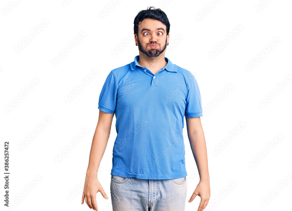 Young hispanic man wearing casual clothes making fish face with lips, crazy and comical gesture. funny expression. Young hispanic man wearing casual clothes making fish face with lips, crazy and comical gesture. funny expression.