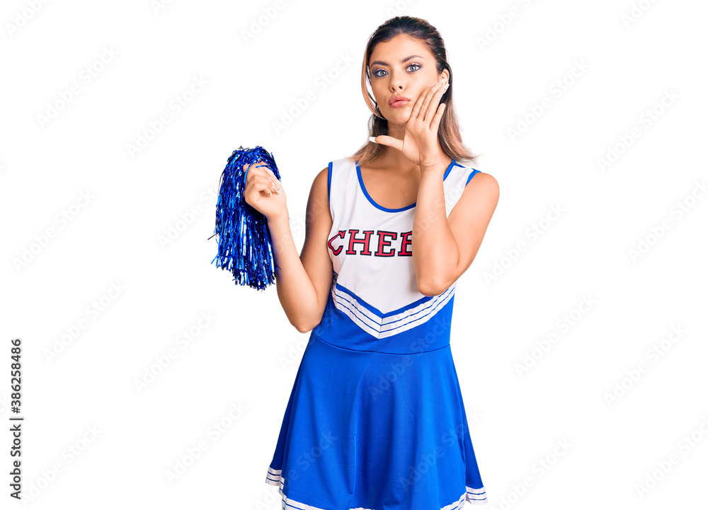 Young beautiful woman wearing cheerleader uniform hand on mouth telling secret rumor, whispering malicious talk conversation Young beautiful woman wearing cheerleader uniform hand on mouth telling secret rumor, whispering malicious talk conversation