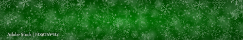 Christmas banner of snowflakes of different shapes, sizes and transparency on green background