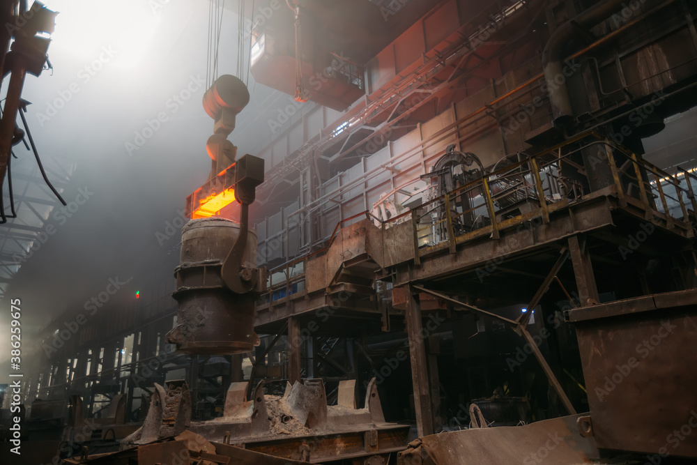Iron casting and the foundry. Overhead crane with ladle with molten metal at metallurgical factory Iron casting and the foundry. Overhead crane with ladle with molten metal at metallurgical factory
