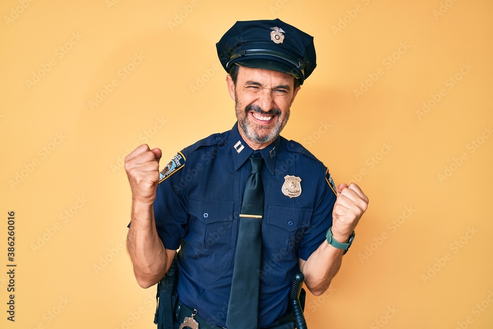 Middle age hispanic man wearing police uniform very happy and excited doing winner gesture with arms raised, smiling and screaming for success. celebration concept. Middle age hispanic man wearing police uniform very happy and excited doing winner gesture with arms raised, smiling and screaming for success. celebration concept.