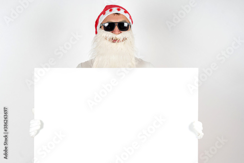 Santa Claus holds a white sign for the inscription. Isolated on white