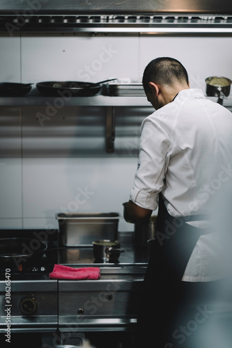 Portrait of a male chef backwards cooking in a restaurant kitchen.