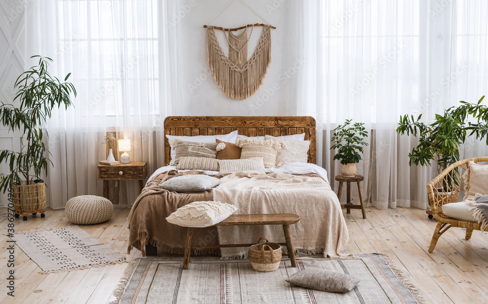 Rustic home design with ethnic boho decoration. Bed with pillows, wooden furniture - obrazy, fototapety, plakaty 