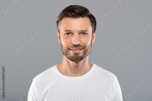 Portrait of handsome cheerful man on grey © Prostock-studio