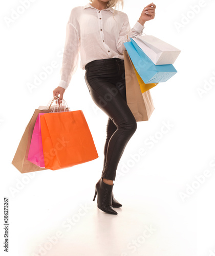 Girl standing on a white background with packages in hands after shopping. The buyer stands on a white background with packages in hands.