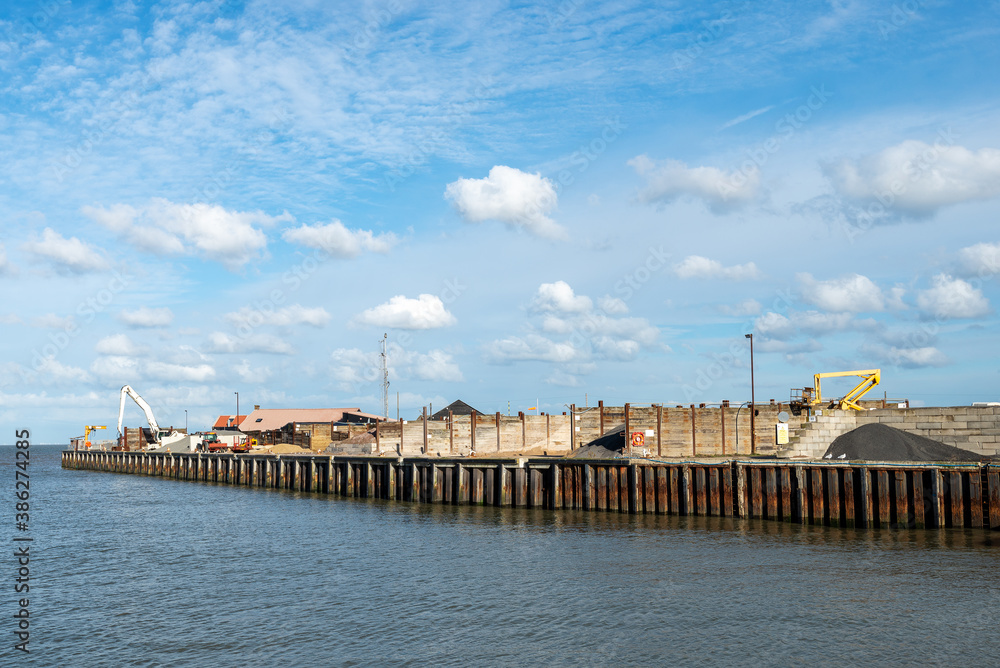 View out to sea from Whitstable Harbour showing industrial land along the right hand side of the marina.