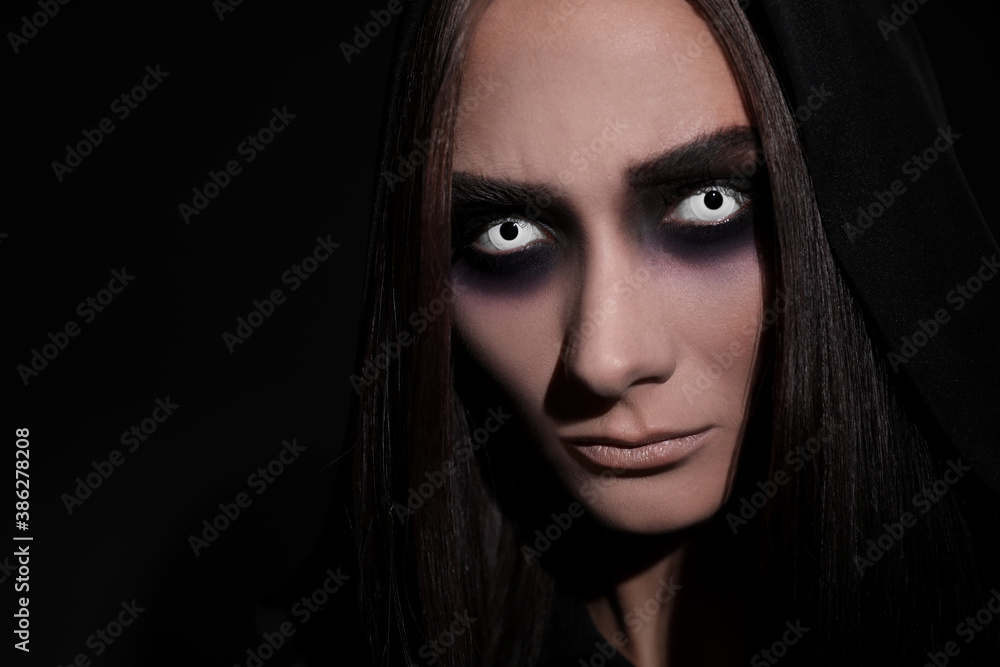 Mysterious witch with spooky eyes on black background, closeup Mysterious witch with spooky eyes on black background, closeup
