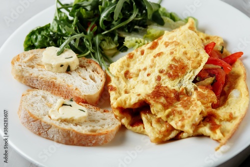 omelet with pepper and baguette, toast on a plate