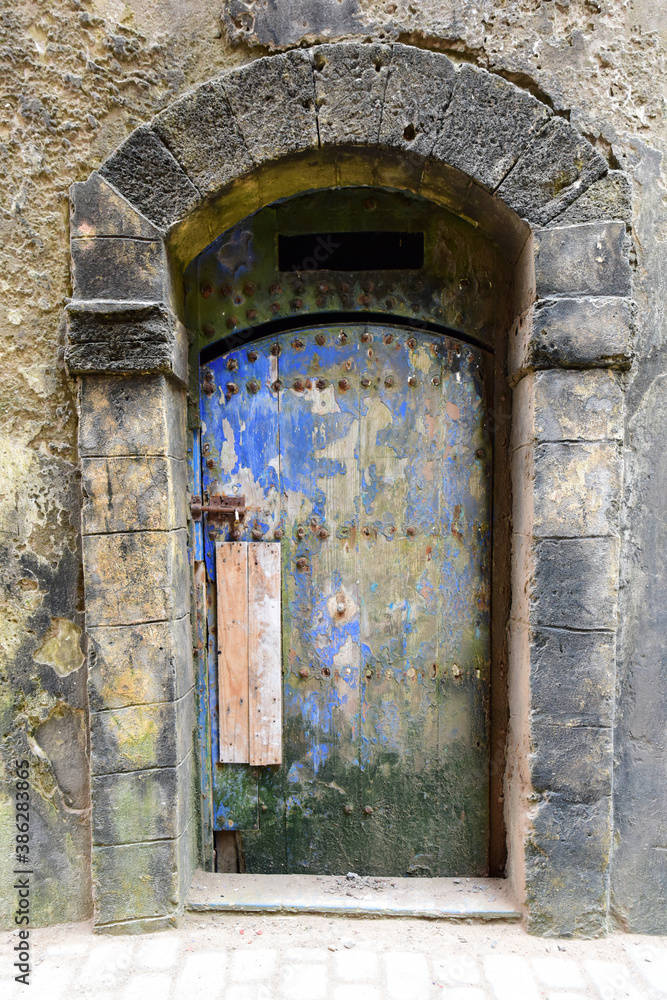 Ancient stone arched entrance with old wooden door, Essaouira, Morocco Ancient stone arched entrance with old wooden door, Essaouira, Morocco