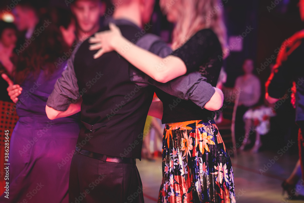 Couples dancing traditional latin argentinian dance milonga in the ballroom, tango salsa bachata lesson in the red lights, dance festival - obrazy, fototapety, plakaty 