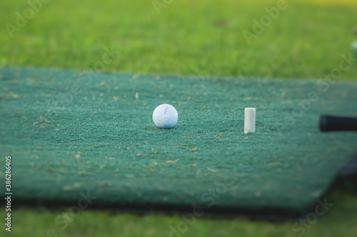 Group of golfers practicing and training golf swing on driving range practice, men playing on golf course, golf ball at golfing complex club resort