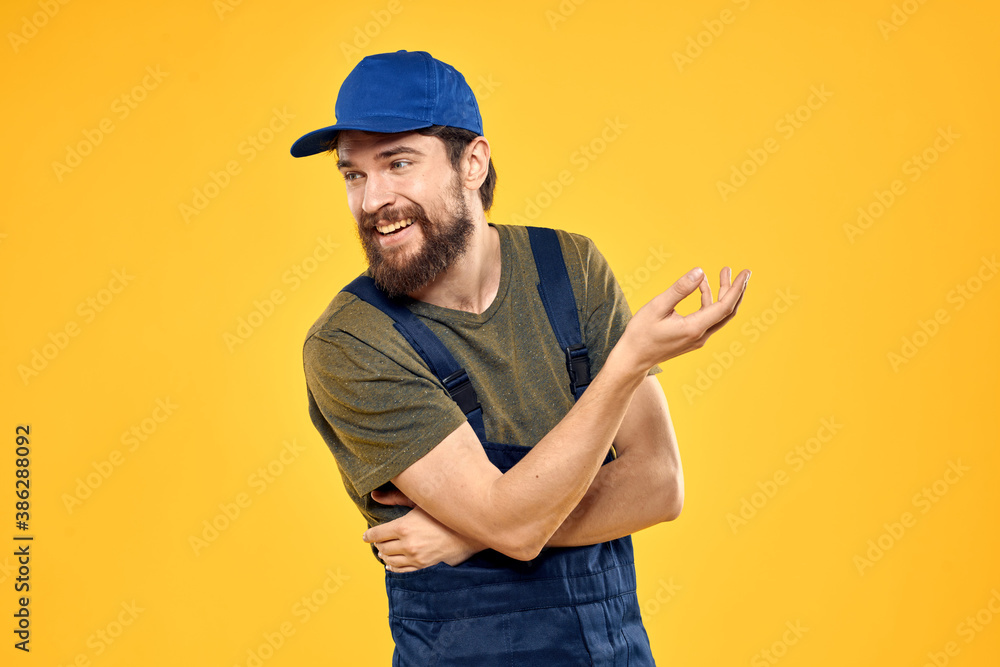 man in work uniform rendering service forklift work lifestyle yellow background