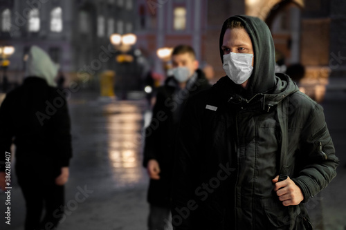 Teenager with backpack going home after school, walking through the city and wearing mask, pandemics concept. © phoenix021
