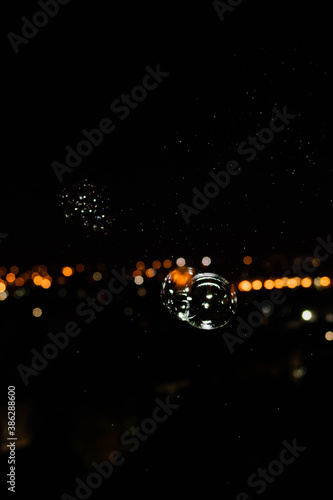 burbujas pompas de jabon sobre luces de ciudad en el horizonte de noche oscura  photo