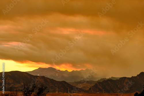 Smoke from the Cameron Peak forest fire rolling through the Rockies, obscuring the mountain range and sunset, Colorado 2020