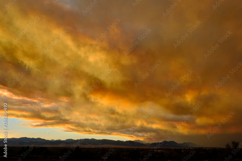 Smoke from the nearby Cameron Peak forest fire mixes with the clouds during sunset creating unique colors in Westminster, Colorado, 2020