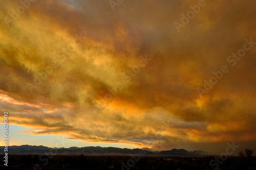 Smoke from the nearby Cameron Peak forest fire mixes with the clouds during sunset creating unique colors in Westminster, Colorado, 2020