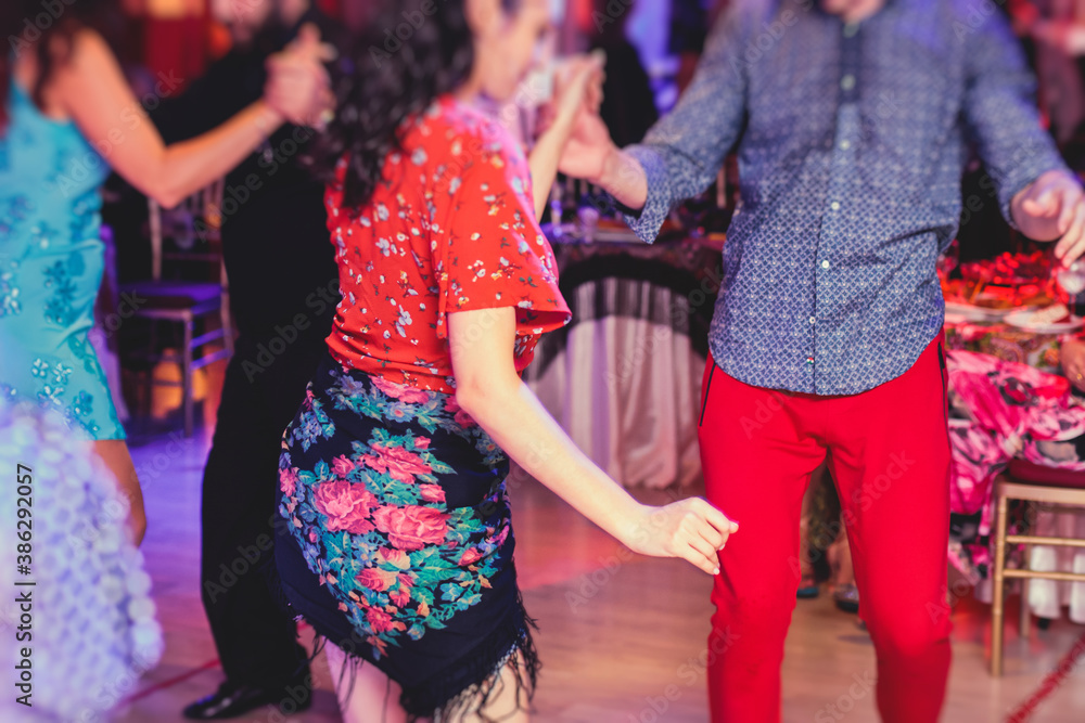 Obraz premium Couples and women wearing red skirts and dress dancing traditional gypsy dance in the ballroom hall