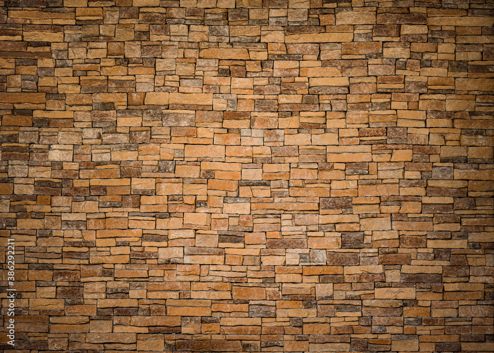 Fototapeta premium background and texture of yellow decorative stone wall surface.