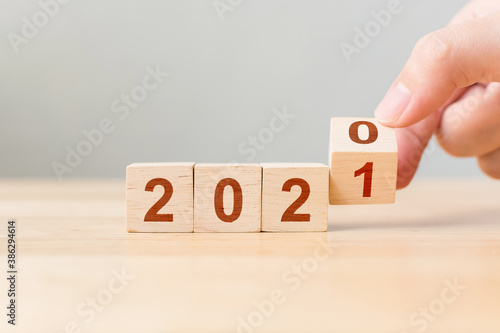 New year 2020 change to 2021. Hand flip over wooden cube block. New year resolution goal concept