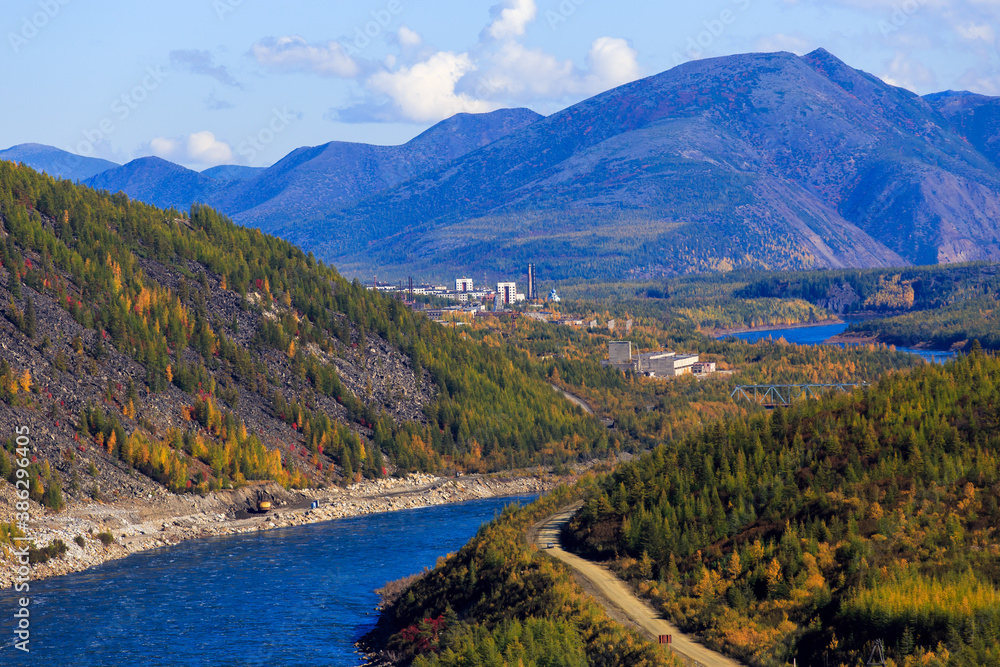 Fototapeta premium The nature of the Magadan region. High mountains on the background of a blue river in the Russian tundra