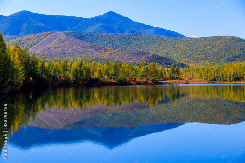 The nature of the Magadan region. High mountains on the background of a blue river in the Russian tundra The nature of the Magadan region. High mountains on the background of a blue river in the Russian tundra