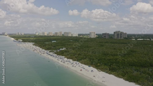 North Naples Florida Aerial v10 pan right shot of Pelican Bay area, Clam Pass Park and crowded beach - March 2020 photo