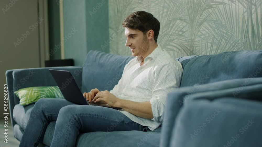 Successful guy receiving message laptop indoors. Happy man doing winner gesture Successful guy receiving message laptop indoors. Happy man doing winner gesture