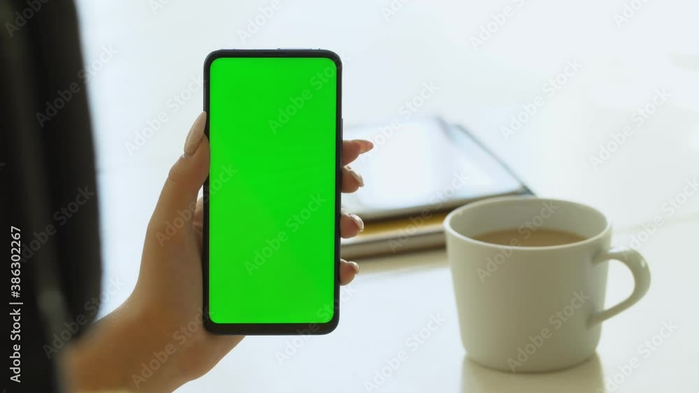 Handheld Camera: Point of View of Woman at Room Sitting on a Chair Using Phone With Green Mock-up Screen Chroma Key Surfing Internet Watching Content Videos Blogs Handheld Camera: Point of View of Woman at Room Sitting on a Chair Using Phone With Green Mock-up Screen Chroma Key Surfing Internet Watching Content Videos Blogs