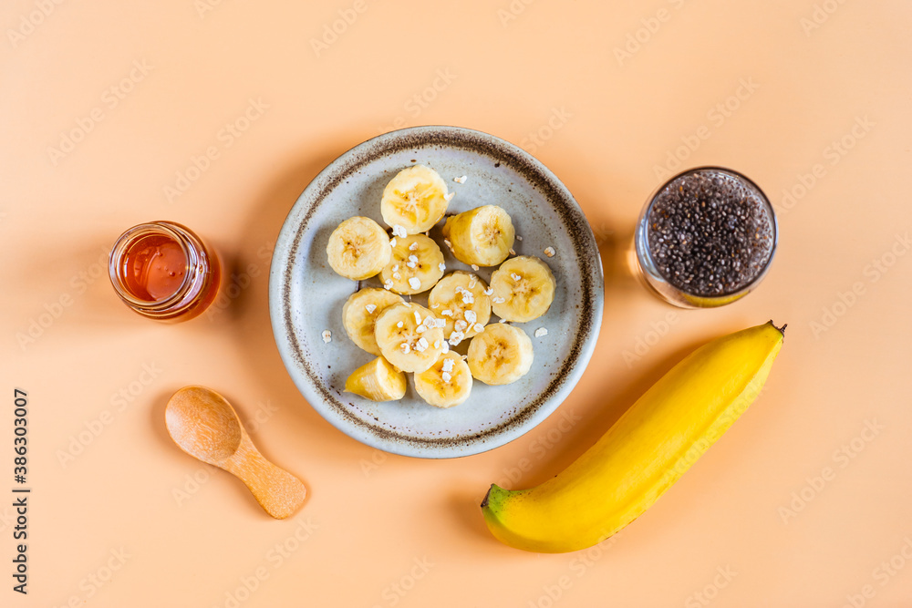 Top view of sliced banana, chia seed and honey, Healthy food on pastel orange background Top view of sliced banana, chia seed and honey, Healthy food on pastel orange background