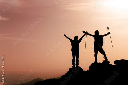 Happy couple watching a beautiful sunrise in the mountains