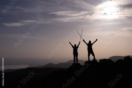 Young couple cheering on mountain peak