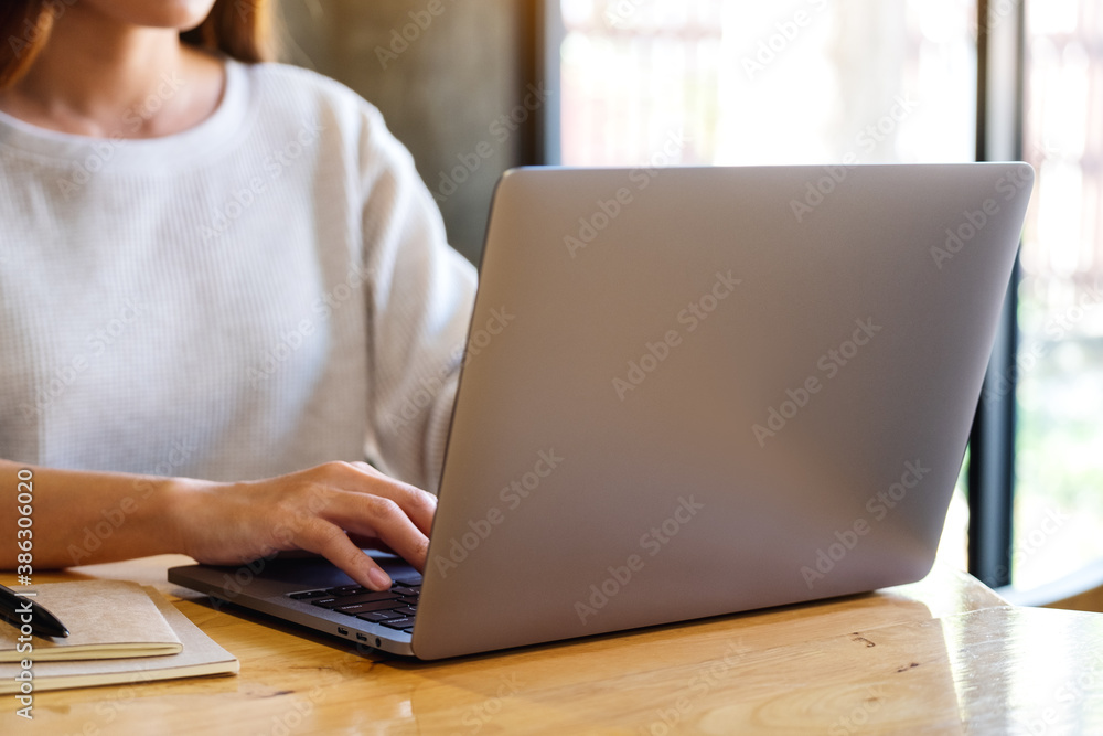 Closeup image of a woman working and typing on laptop computer keyboard on the table Closeup image of a woman working and typing on laptop computer keyboard on the table