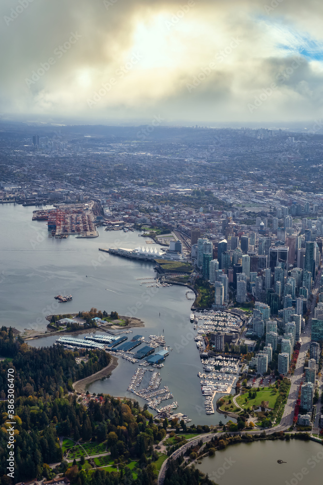 Fototapeta premium Downtown Vancouver, British Columbia, Canada. Aerial View of the Modern Urban City, Stanley Park, Harbour and Port. Viewed from Airplane Above during a sunny morning. Sunny Morning Artistic Render