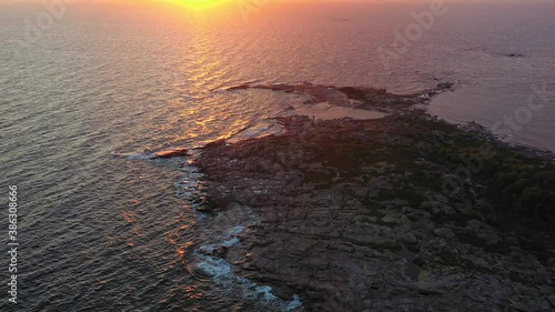 Drone shot of a remote rocky island, surrounded by the open ocean, during sunset, on the gulf of Finland - static, aerial view