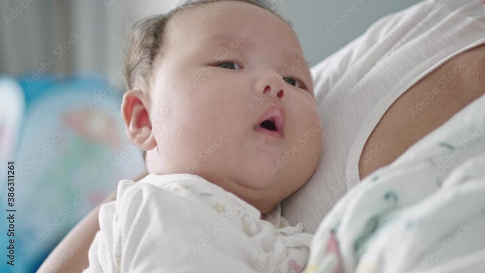 2 month old Asian baby in the arms of her mother. 2 month old Asian baby in the arms of her mother.