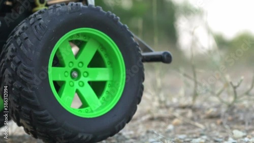Close up on front  wheels of Rc monster truck, moving back and forth on soil ground 120fps photo