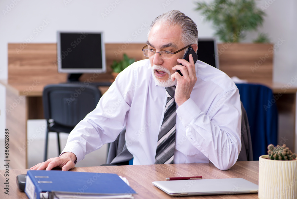 Old male employee suffering from radiculitis at workplace Old male employee suffering from radiculitis at workplace