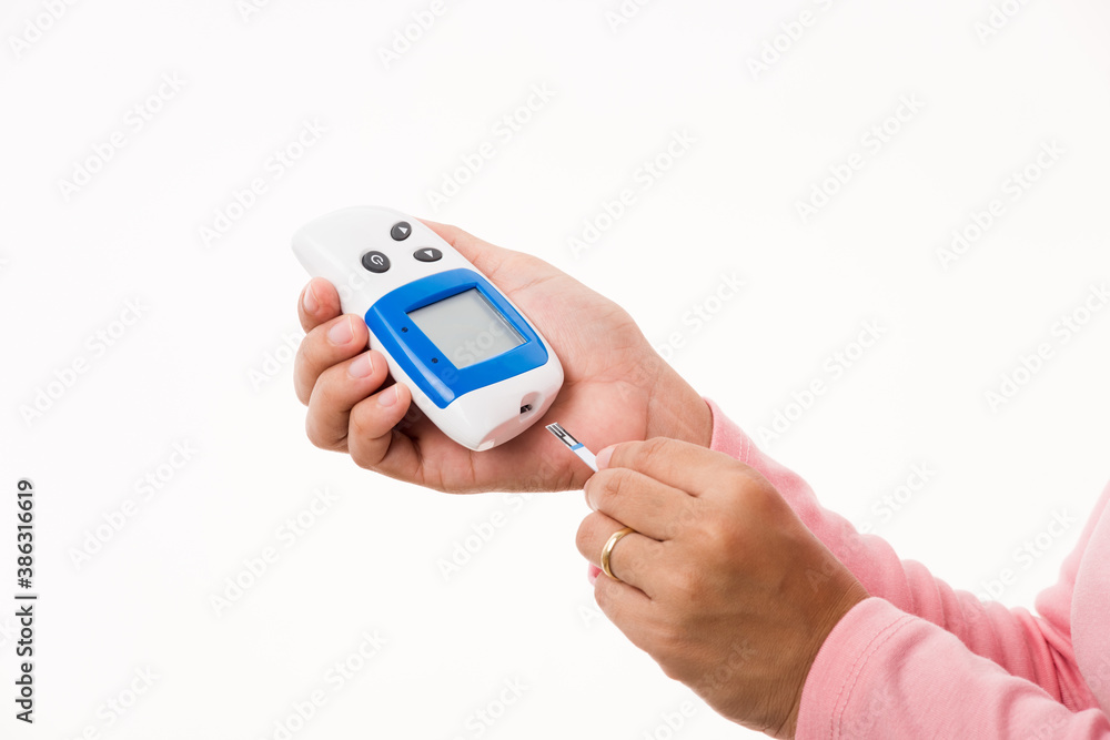Closeup hand woman measuring glucose test level checking on finger by glucometer she monitor and control high blood sugar diabetes and glycemic health care medical concept isolated on white background Closeup hand woman measuring glucose test level checking on finger by glucometer she monitor and control high blood sugar diabetes and glycemic health care medical concept isolated on white background