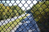 metal fence over highway or road with cars