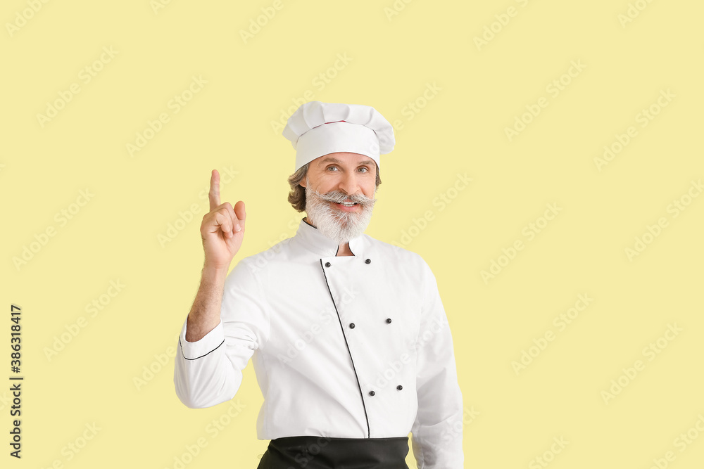 Mature male chef with raised index finger on color background Mature male chef with raised index finger on color background