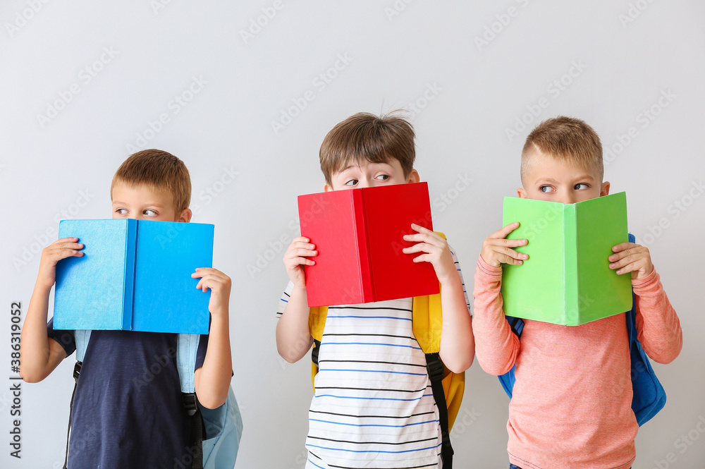 Cute pupils with books on light background Cute pupils with books on light background